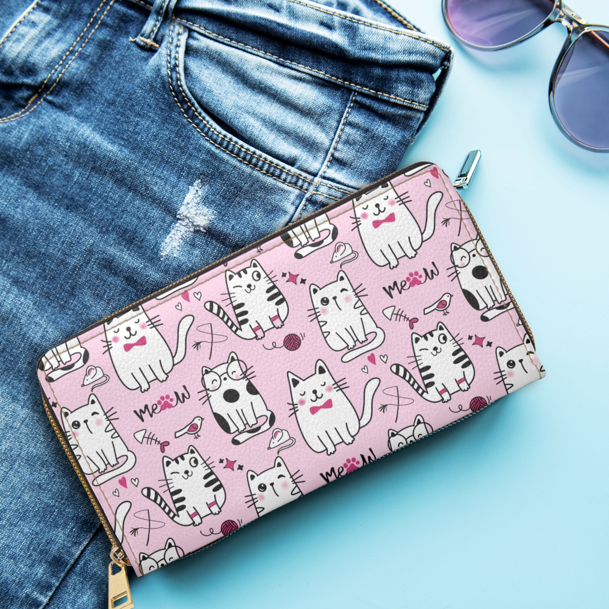 Pink Zipper Wallet with Sassy Cats next to jeans