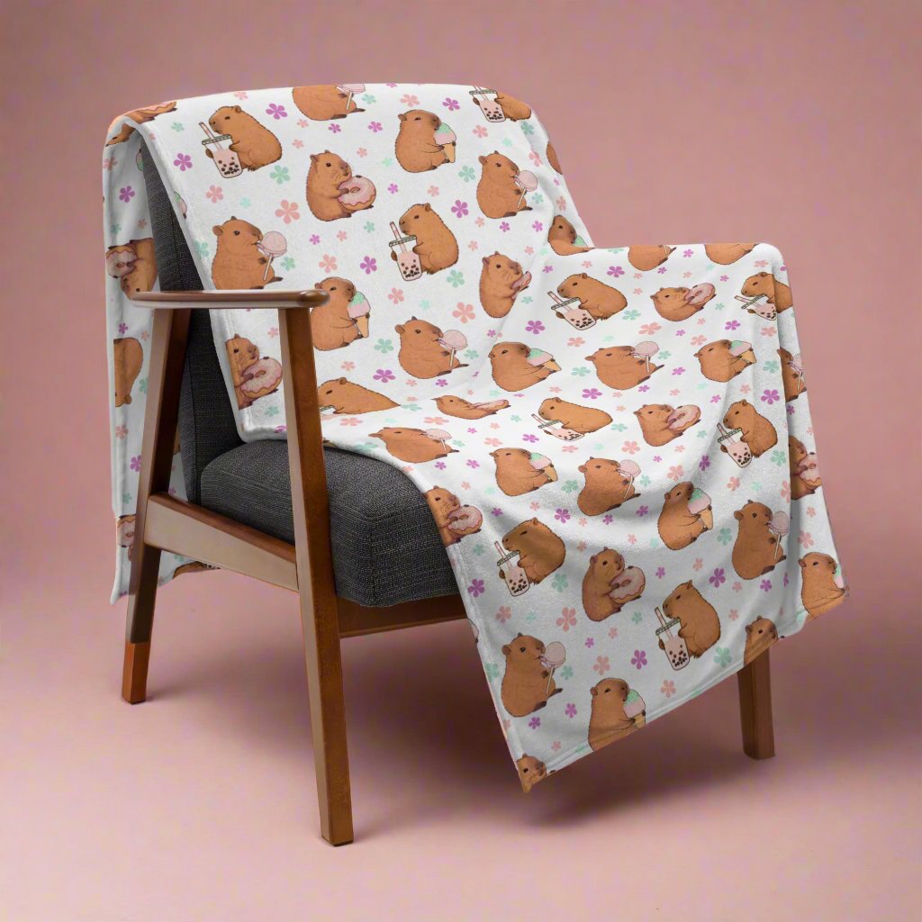 Sweets Loving Capybara Cozy Velveteen Plush Blanket draped over chair